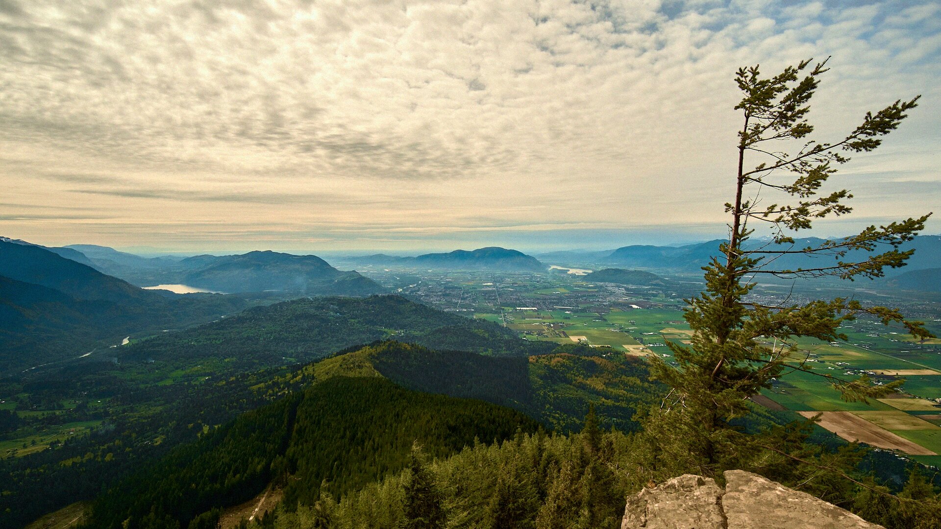 Wide mountain valley view from a North Shore summit above Vancouver, layered ridges fading into a hazy horizon